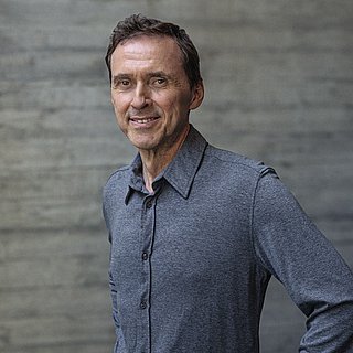 Portait von Inhaber Alwin Roppert vor einer Sichtbetonwand