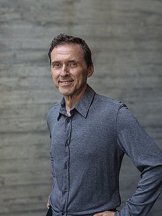 Portait von Inhaber Alwin Roppert vor einer Sichtbetonwand