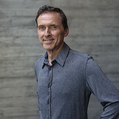 Portait von Inhaber Alwin Roppert vor einer Sichtbetonwand