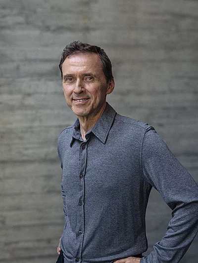 Portait von Inhaber Alwin Roppert vor einer Sichtbetonwand