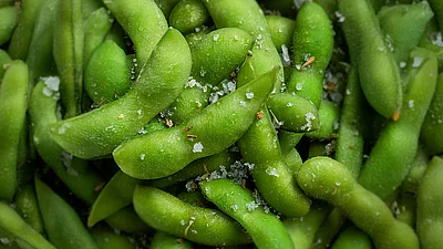 Grüne Edamame-Bohnen in der Schale mit grobem Salz aus der Nahaufnahme
