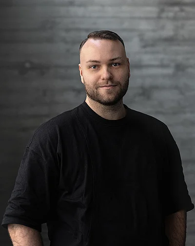 Portrait von Creative Director Design Philipp vor einer Sichtbetonwand