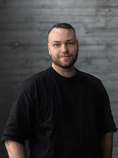 Portrait von Creative Director Design Philipp vor einer Sichtbetonwand