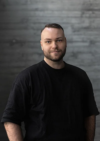 Portrait von Creative Director Design Philipp vor einer Sichtbetonwand