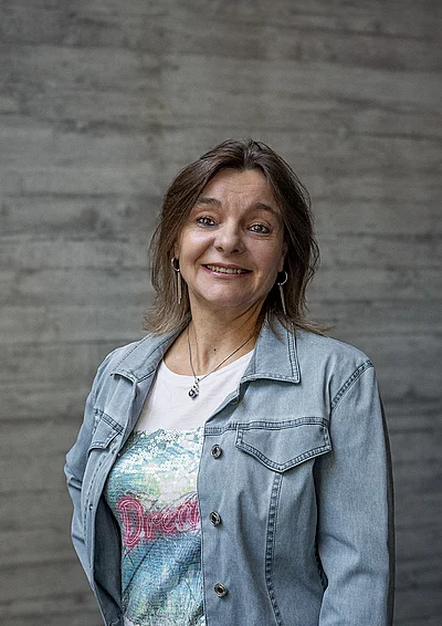 Portrait von Estelle, Finance und Administration, vor einer grauen Sichtbetonwand