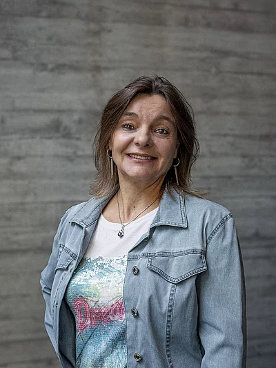 Portrait von Estelle, Finance und Administration, vor einer grauen Sichtbetonwand