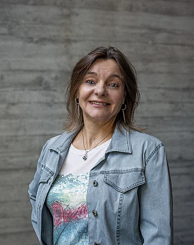 Portrait von Estelle, Finance und Administration, vor einer grauen Sichtbetonwand
