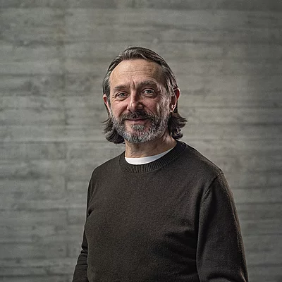 Portrait des Creative-Director Konzept vor einer Sichtbetonwand.