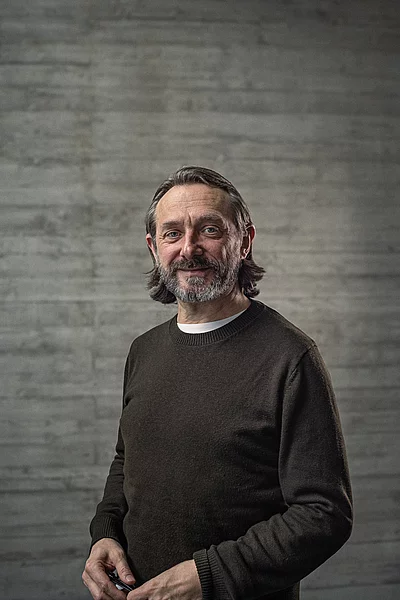 Portrait des Creative-Director Konzept vor einer Sichtbetonwand.