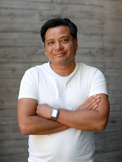 Portrait von Chai Sinthuaree, Geschäftsführer und Inhaber, vor einer grauen Sichtbetonwand