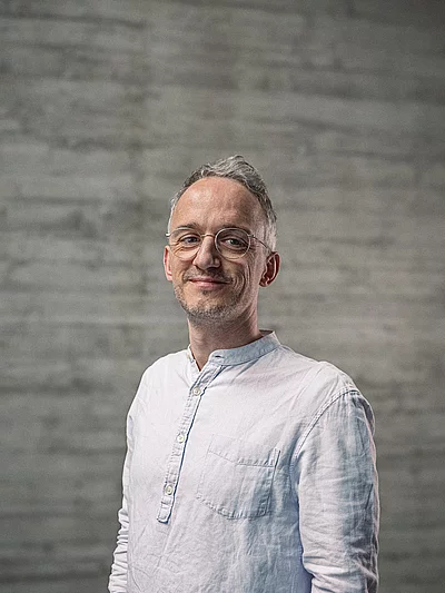 Portrait des Teamlead Backend vor einer Sichtbetonwand.