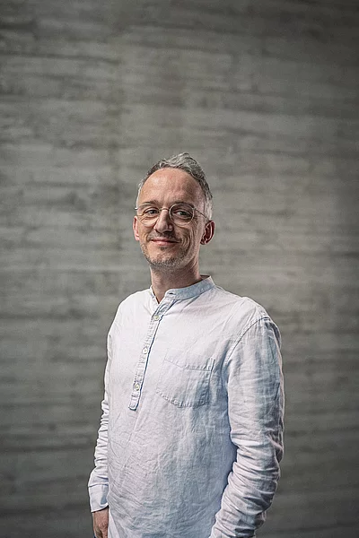 Portrait des Teamlead Backend vor einer Sichtbetonwand.