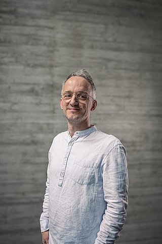 Portrait des Teamlead Backend vor einer Sichtbetonwand.