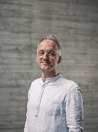 Portrait des Teamlead Backend vor einer Sichtbetonwand.